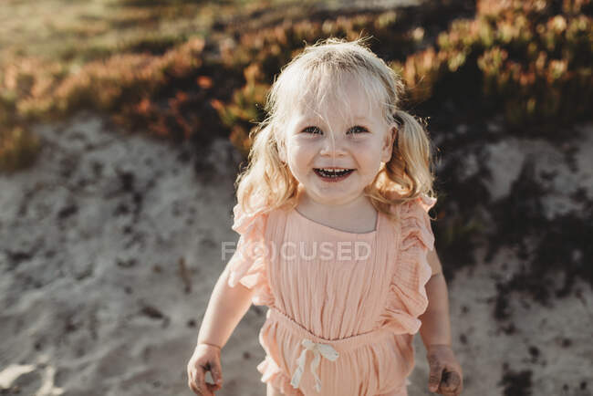 Portrait of young toddler girl with pigtails smiling on beach — Stock Photo