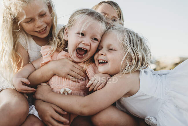 Молоді сестри сміються в оточенні дітей — Stock Photo