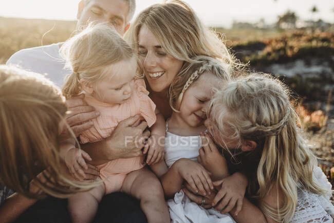 Estilo de vida close up de família com jovens irmãs sentadas na praia — Fotografia de Stock