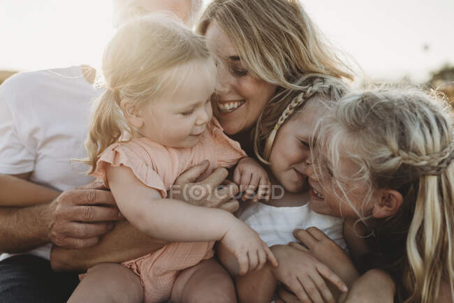 Mode de vie gros plan de la famille avec de jeunes sœurs assises sur la plage — Photo de stock