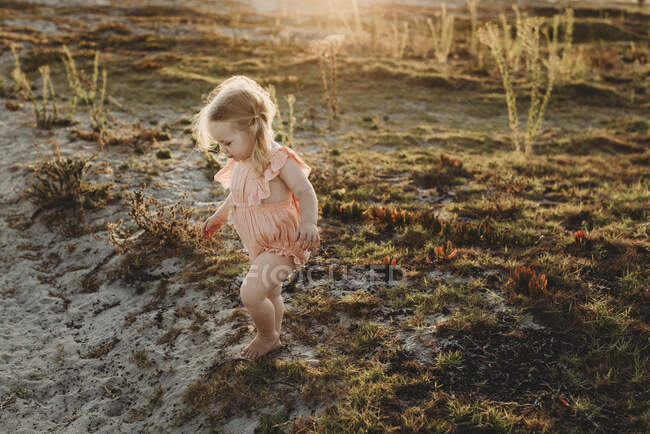 Lifestyle portrait of toddler girl walking away at beach sunset — Stock Photo