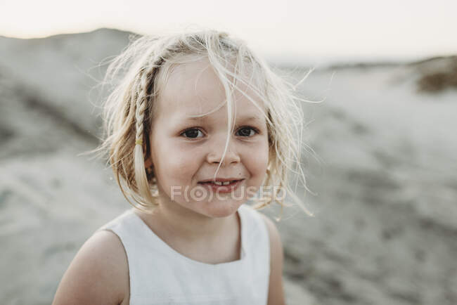 Portrait of preschool-aged girl smiling at beach — Stock Photo