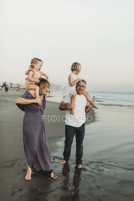 Immagine di stile di vita di madre e padre che tengono giovani figlie su dovrebbe — Foto stock