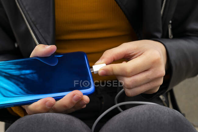 Mão conectando cabo Micro USB para o celular. — Fotografia de Stock