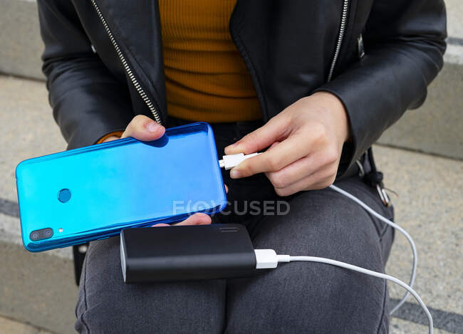 Woman connecting the mobile to a Powerbank. — Stock Photo