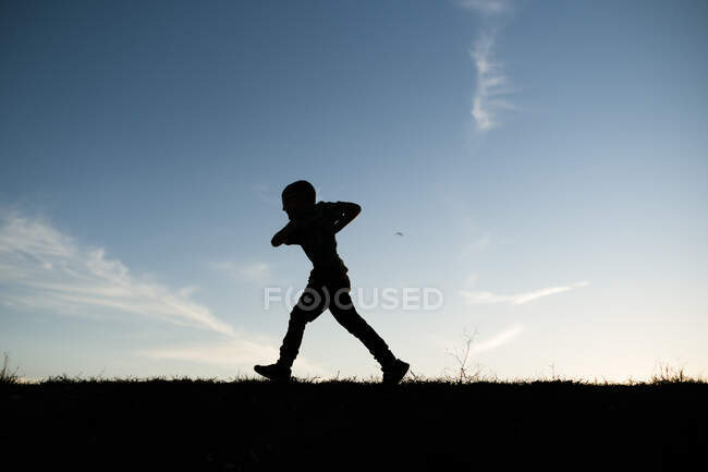 Silhouetted Boy corriendo en la colina en Waco Texas - foto de stock