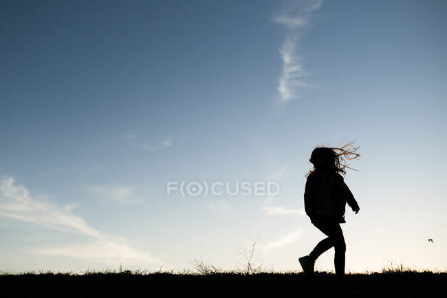 Silueta chica jugando a correr en la colina en Waco Texas - foto de stock