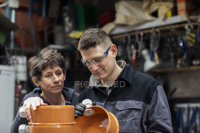 Encanador homem e líder mulher trabalhando em um workshop — Fotografia de Stock