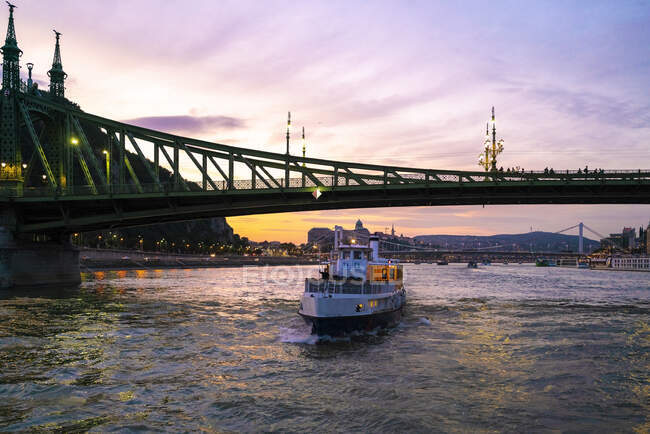 Ponte Liberty ao pôr-do-sol com a ponte Elisabeth e um barco de cruzeiro — Fotografia de Stock