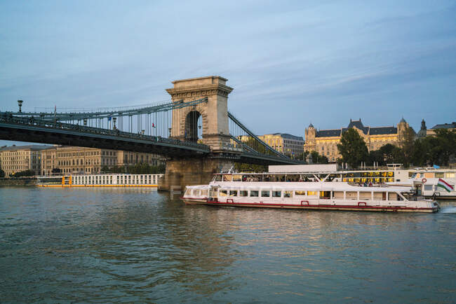 Tramonto barca da crociera da Szchenyi Chain Bridge e quattro stagioni hotel — Foto stock