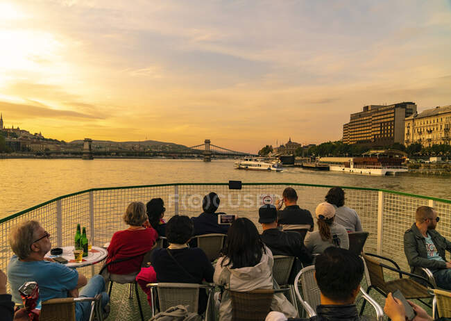 Turisti che godono della vista del danube da una barca da crociera entro il tramonto — Foto stock