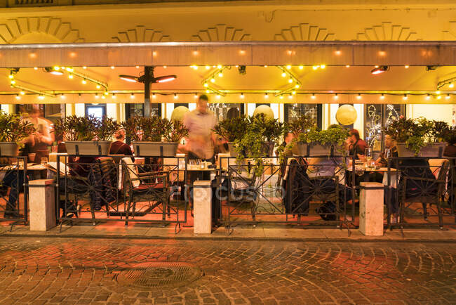 Иллюминированный уютный ресторан ночью в вредителях — стоковое фото