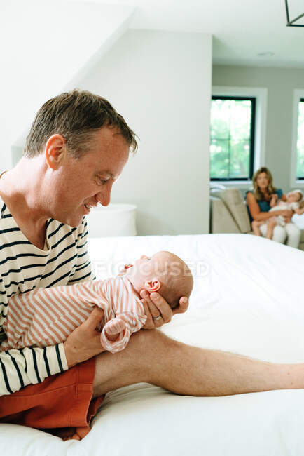 Bello felice padre tenendo il suo bambino figlio a casa — Foto stock