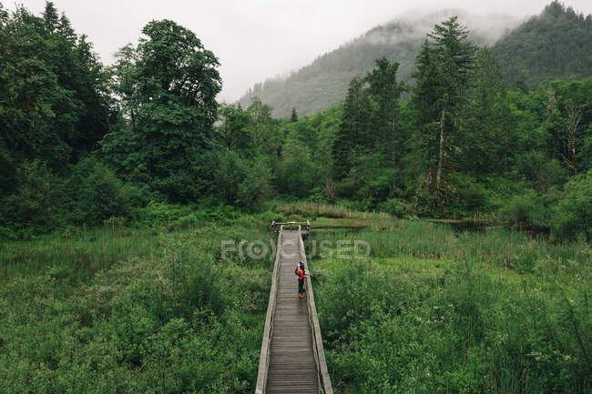 A young couple enjoys a hike on a boardwalk in the Pacific Northwest — Stock Photo