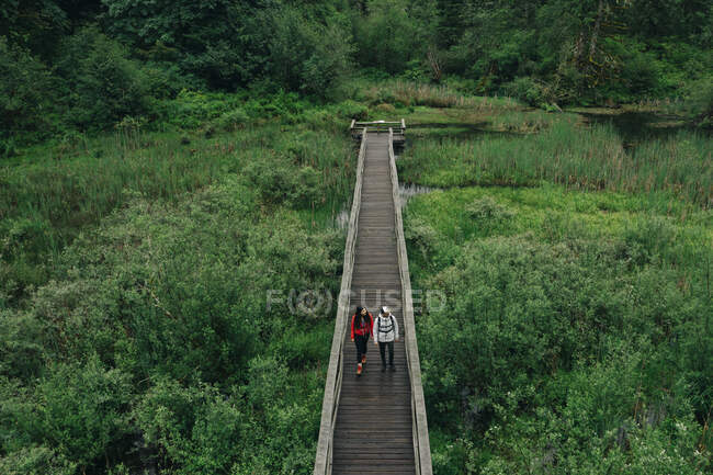 Una giovane coppia si gode un'escursione su una passerella nel Pacifico nord-occidentale — Foto stock