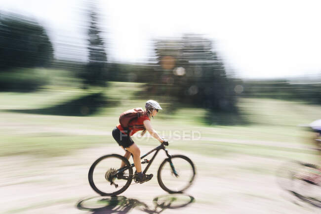 A young woman rides her mountain bike near Mount Hood, Oregon. — Stock Photo