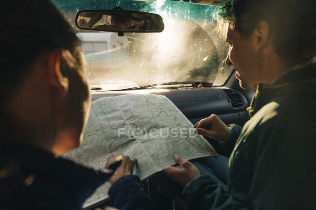 Un jeune couple regarde la carte lors d'un road trip. — Photo de stock