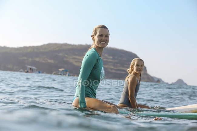 Surfistas femeninas jóvenes en tabla de surf - foto de stock