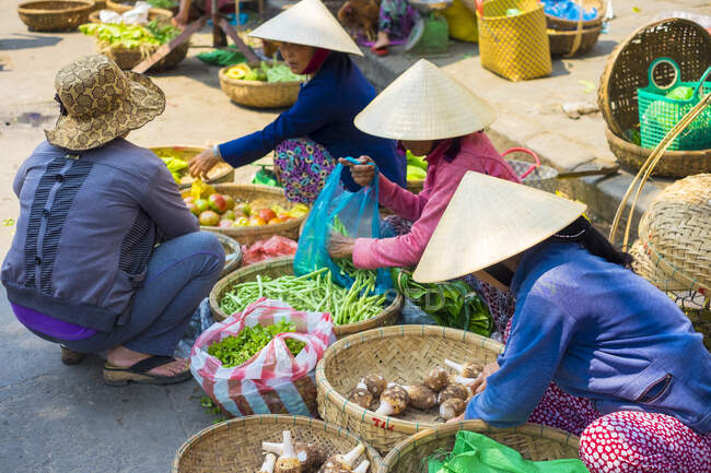 Mujeres vendiendo verduras en el mercado Hoi An, provincia de Quang Nam, Vietnam - foto de stock