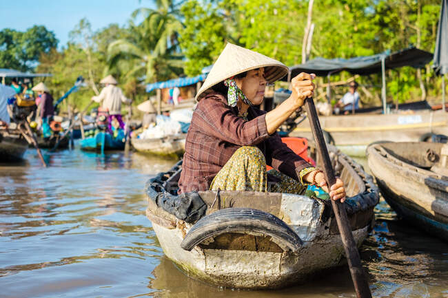 Une Vietnamienne pagaie sur un petit bateau au marché flottant de Phong Dien, district de Phong Dien, Can Tho, delta du Mékong, Vietnam — Photo de stock