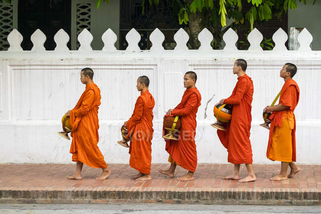 Buddhistische Novizenmönche stehen Schlange, um im Morgengrauen Almosen (Tak Bat) zu empfangen, Luang Prabang, Provinz Louangphabang, Laos — Stockfoto