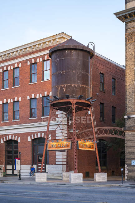 Estados Unidos, Alabama, Montgomery. Edificios históricos y torre de agua en la calle Tallapoosa al atardecer. - foto de stock
