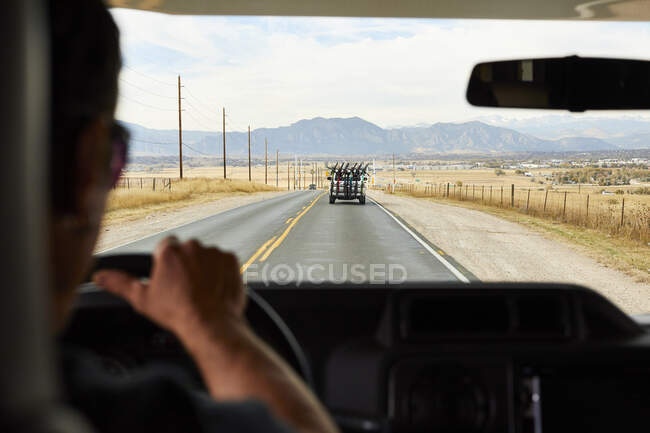 Uma vista das montanhas da estrada e um caminhão na frente de nós cheio de bicicletas. — Fotografia de Stock