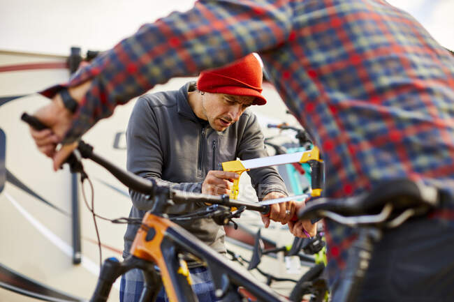 Mountain bikers working together to cut down handlebars. — Stock Photo