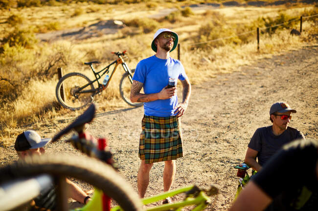 Mountain bikers having drinks after their ride. — Stock Photo