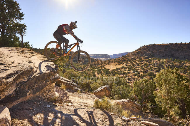 Un uomo salta la sua mountain bike su un sentiero in Colorado. — Foto stock