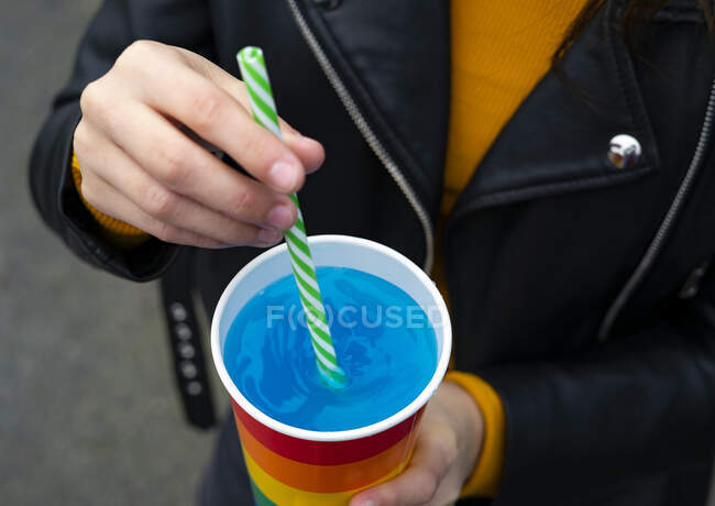 Mixing a blue cocktail with a colorful straw. Cocktail concept and party. — Stock Photo
