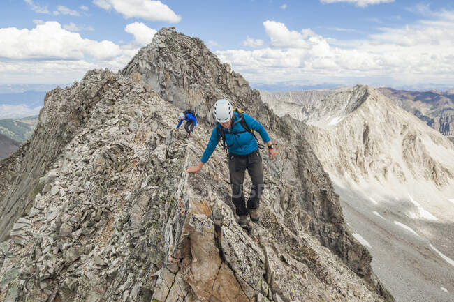 Женщины взбираются на узкий хребет на Капитолийском пике, Лосиные горы, Колорадо — стоковое фото