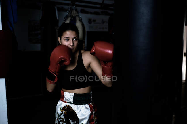 Jovem praticando boxe no ginásio — Fotografia de Stock
