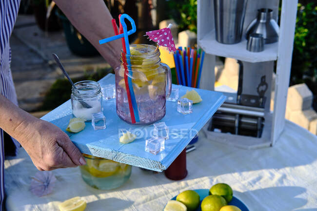 Kellnerin bringt Cocktail auf ihr blaues Holztablett — Stockfoto