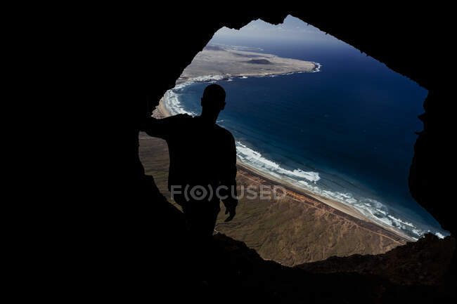 Silhouette of a man from cave on the Famara cliff in Lanzarote, Spain — Stock Photo