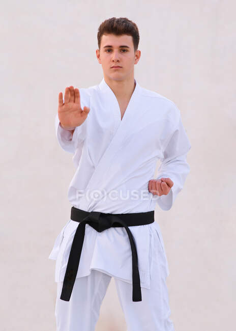 Teenager boy karate expert practicing fighting positions with hi — Stock Photo
