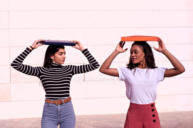 Two student friends, one Arab and one African-American, play with folders after class — Stock Photo