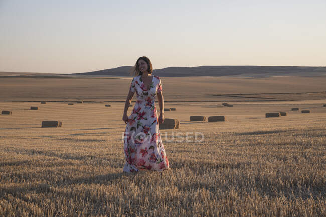 Donna in piedi nel campo di grano al tramonto — Foto stock