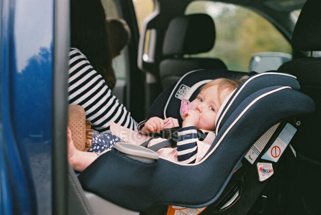 Little baby girl in a rear facing car seat. — Stock Photo