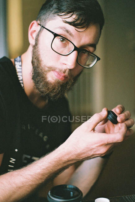 Young man performing maintenance on a camera lens. — Stock Photo
