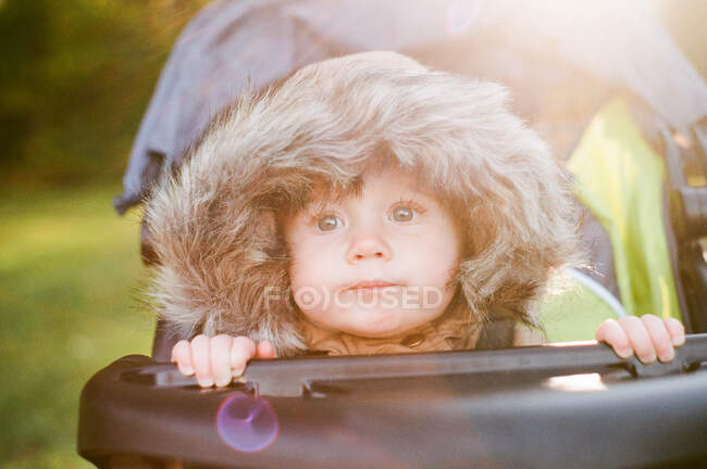 Little baby girl with a furry hood on. — Stock Photo