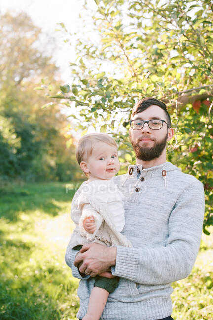 Ein Vater und seine Tochter neben einem Apfelbaum. — Stockfoto