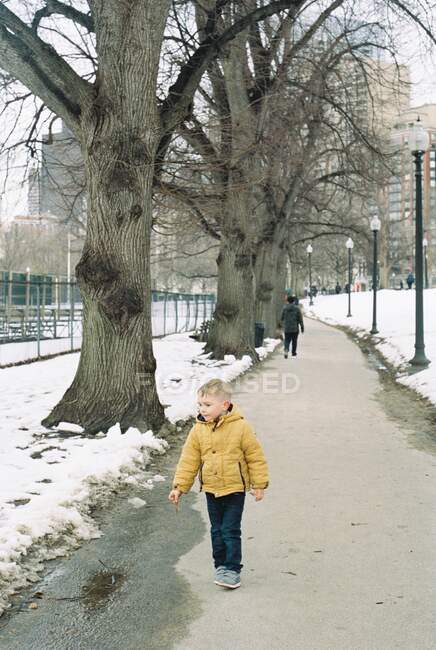 A little three year old boy in boston wearing a yellow jacket — Stock Photo