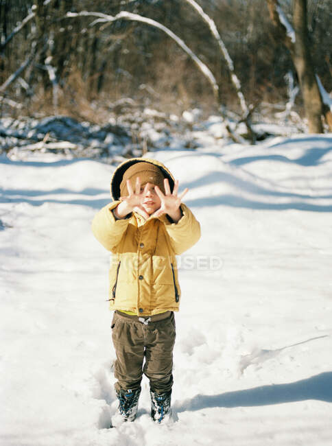 Маленький мальчик с холодными руками в снежный зимний день. — стоковое фото