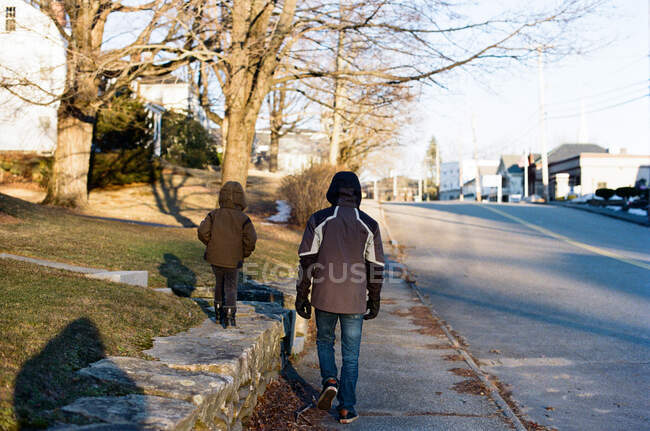 Отец и сын на прогулке в холодный, но солнечный зимний день. — стоковое фото