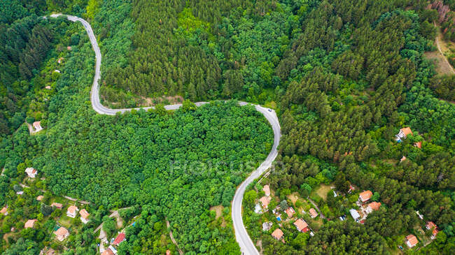 Vista aérea da estrada sinuosa através das densas florestas na alta montanha na Bulgária. — Fotografia de Stock