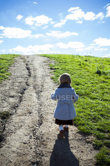 Joven chica elegante caminando por sendero cubierto de hierba en Detroit MI - foto de stock