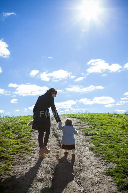 Mother and daughter hand in hand walking up pathway in Detroit MI — Stock Photo