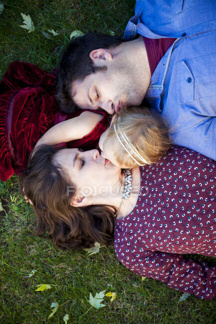 Giovane coppia baciare figlia su erba a Detroit MI — Foto stock