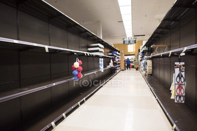 Se agotó la sección de productos de papel de un mercado debido al Coronavirus. - foto de stock